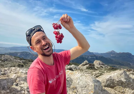 Leader with charcuterie platter, pretending to eat grapes.
