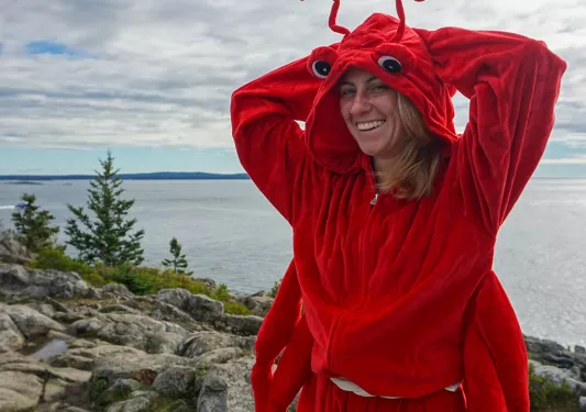 Guest/leader in lobster costume, large lake/ocean in background.