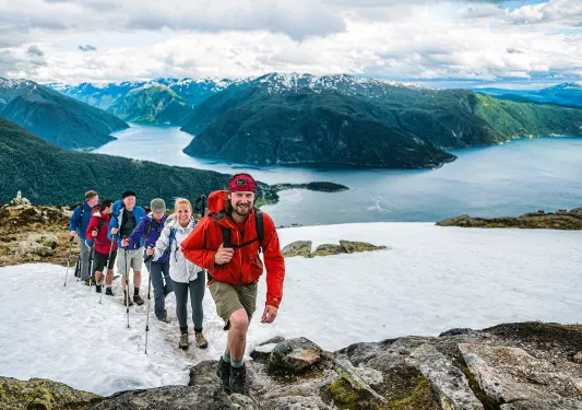 Hikers climbing a snowy ridge in Norway