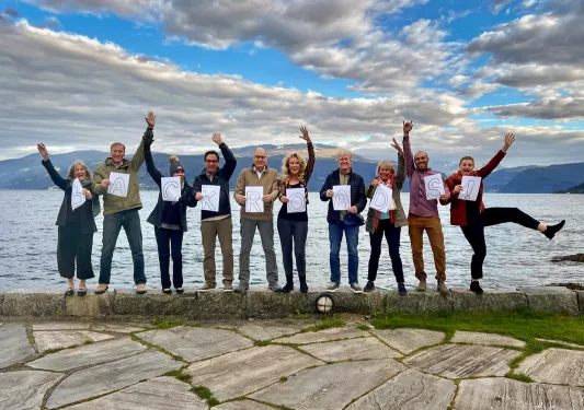 Group of hikers holding up a sign that spells our Backroads