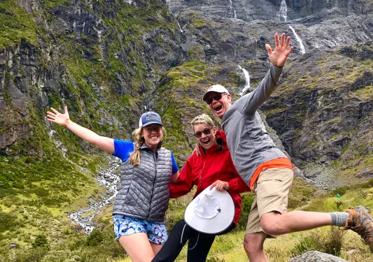 Guests excitedly posing on a rock in New Zealand