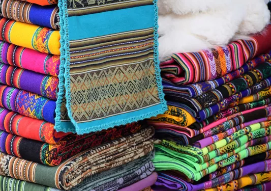 Colorful pile of textiles, numerous different patterns and colors.