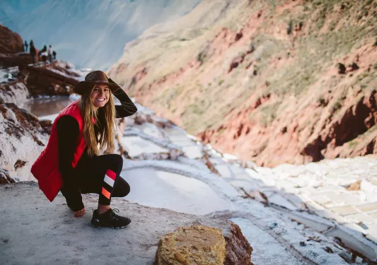 Backroads guest crouching in snow on hiking trail in Peru.