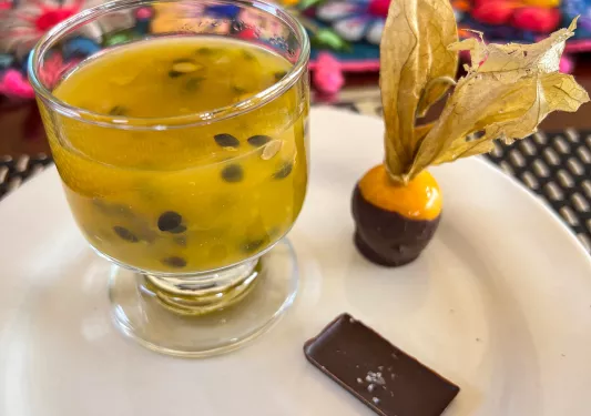 Fancy platter of seedy beverage and small chocolates.