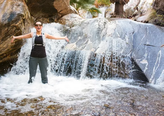 Woman with arms out in a waterfall