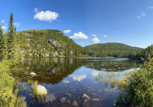 Wide shot of large lake, guest on left, looking out towards mountains.