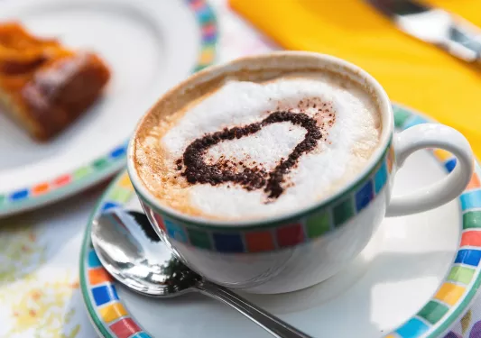 Close up of coffee cup, decorated with sugar heart.