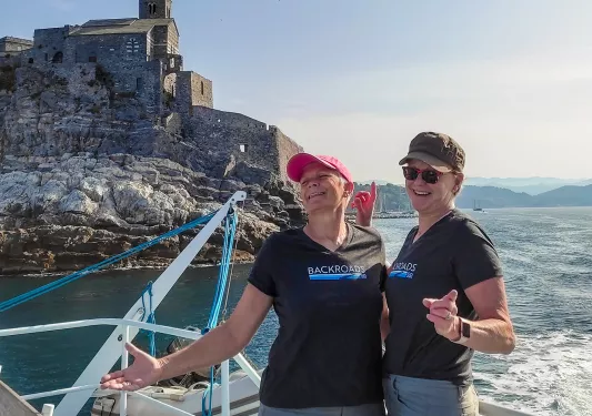 Two women hugging on the deck of a ship at sea.