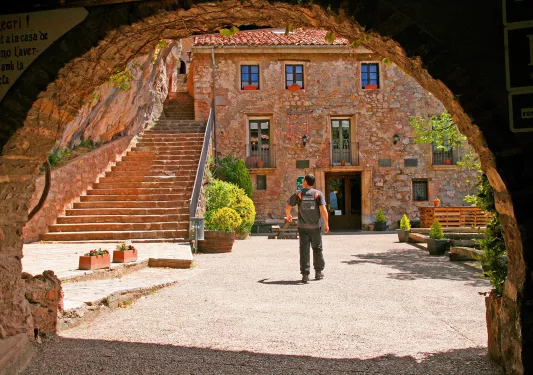 Archway shot of guest amid red brick courtyard.