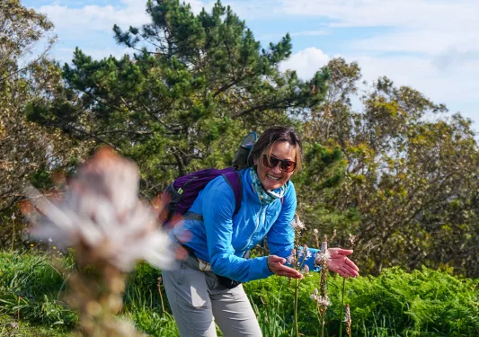 A hiker appreciating flowers