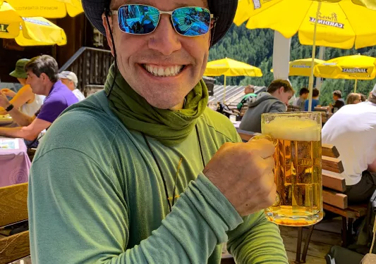 Guest smiling at camera, beer in hand.