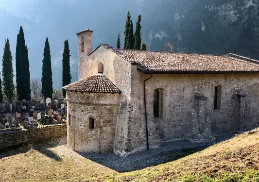 Shot of mountain cemetery building, gravestones in background.