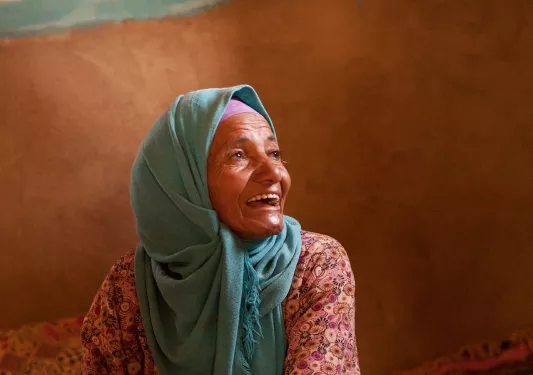 Elderly local pressing something between panels of wood.