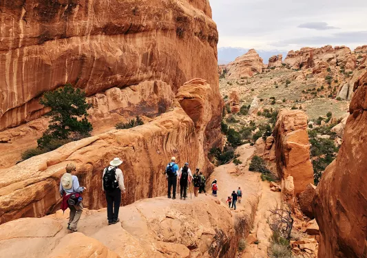 Guests hiking in national park among boulder formations