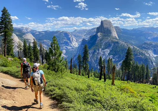Guests hiking with Glacier Point in background.