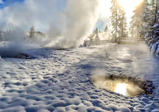 Snow covered landscape and hot springs with steam