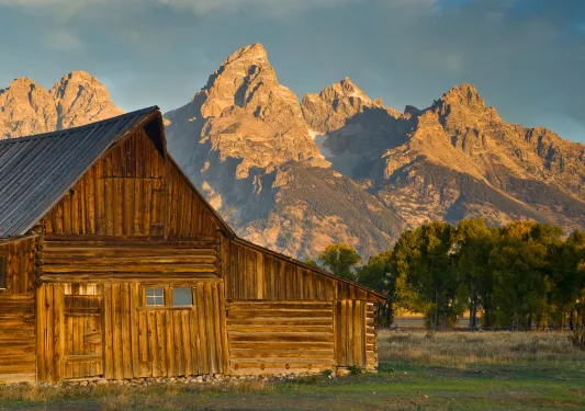 Wooden cabin with rocky mountains in background