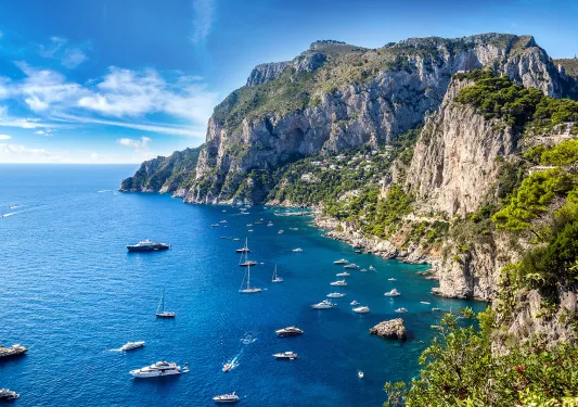 Wide shot of Amalfi Coast, boats dotting the crystal blue water.