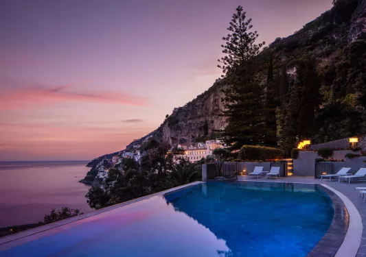 infinity pool looking out over sunset over the amalfi coast