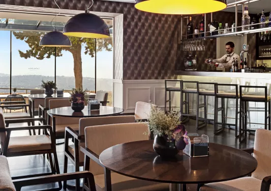 Indoor bar and lounge, with a bartender in the back making drinks