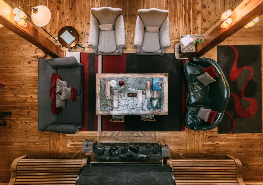 Top view of a lodge lobby with a wooden coffee tables and sofas surrounding the table