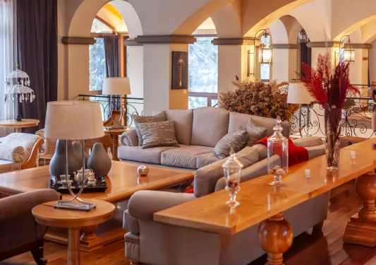 Indoor lobby with gray sofas surrounding a coffee table with large windows in the back
