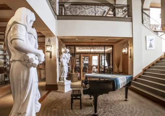 Large lobby with stone statues and a piano in the center