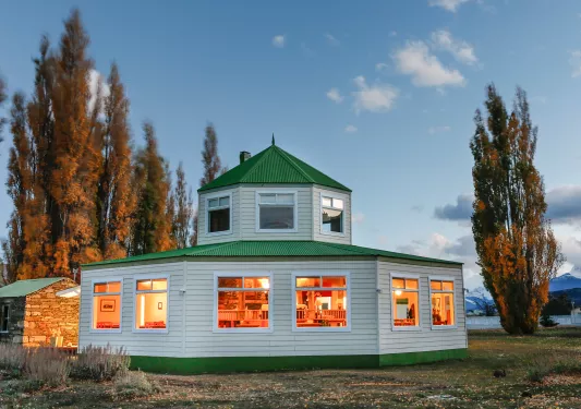 round house with green roof and lit up windows