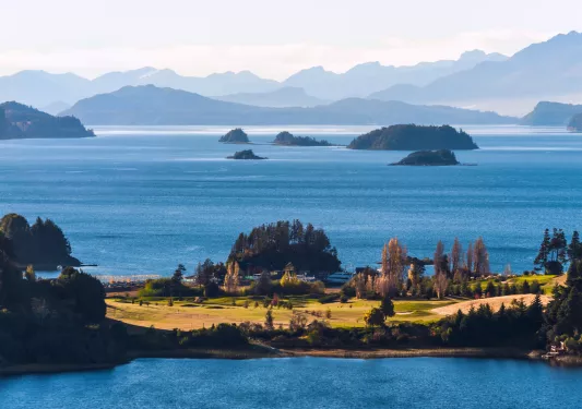 Small island with tall trees, with a vast ocean in the background