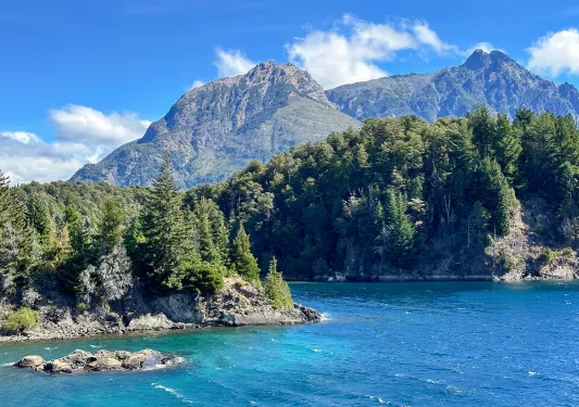 Lake surrounded by large boulders and tall trees