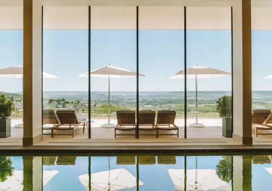 swimming pool with large windows overlooking mountains