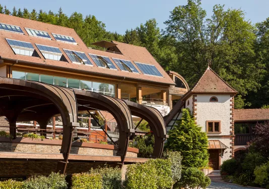 Exterior view of a brown building with large windows and curved archways