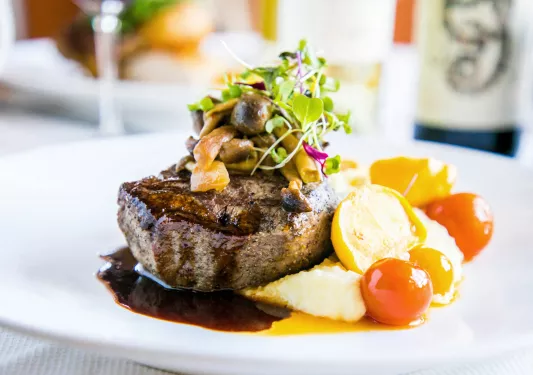 Plate of steak with mushrooms and vegetables on the side