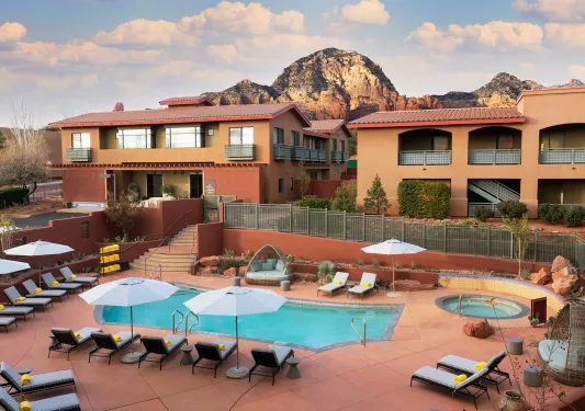 Exterior view of hotel building with outdoor pool and hot tub