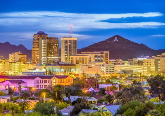 City illuminated by lights, with a large mountain in the distance