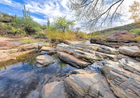 Small pond surrounded by large rocks in a desert valley