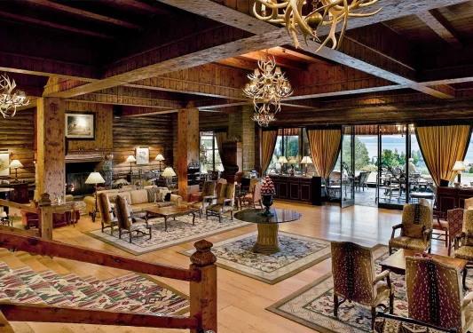 Hotel lobby with cushioned chairs, rugs under furniture, and a fireplace