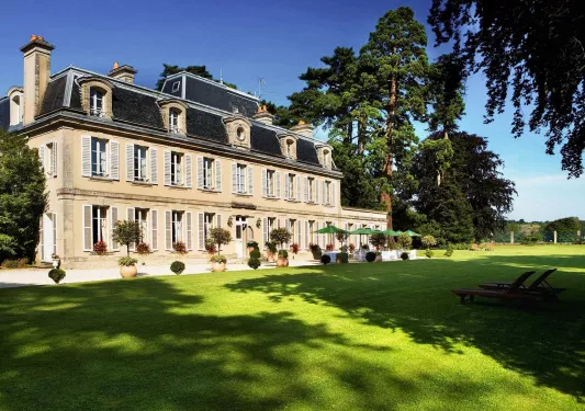 Yellow hotel building with large grass area in front