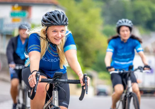 Women in Backroads branded biking gear riding on their bike