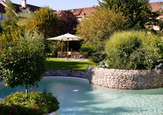 Outdoor garden with tables with plants and a small pond