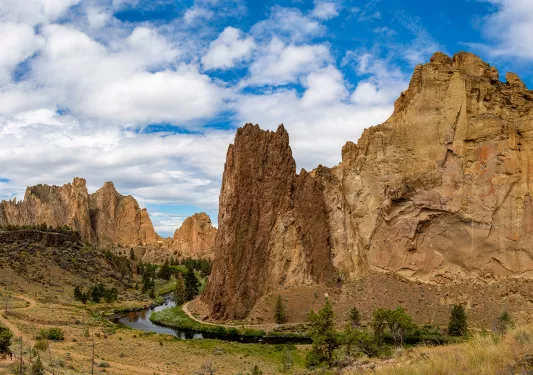 Large, jagged mountains and cliffs in a large gravel valley