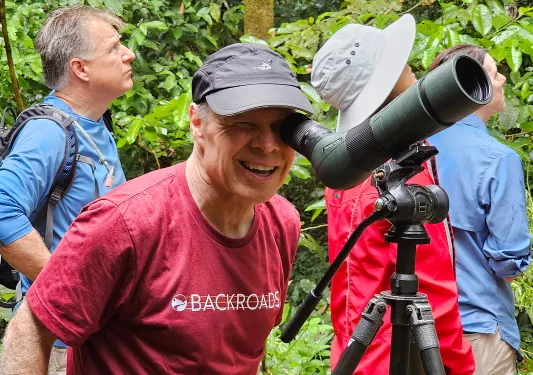 Man looking into a small telescope