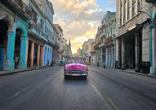 Rear-view car shot of a pink car driving through the streets of an empty town