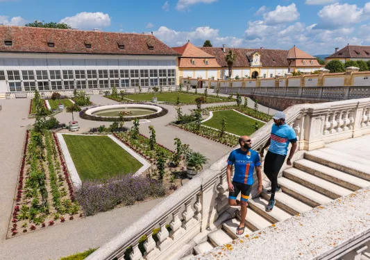 Two men walking down a flight of stairs towards an outdoor garden