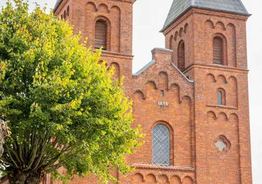 Red brick, castle like buildings with bikers in front