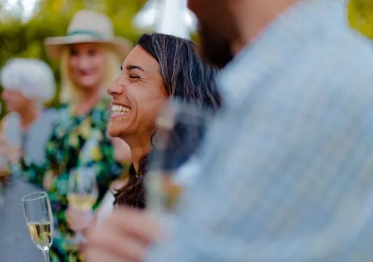 Woman smiling while holding up a glass of wine