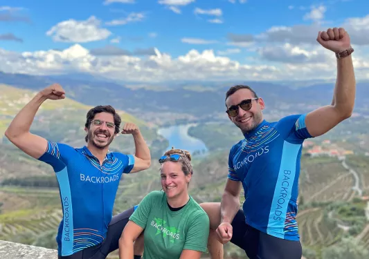 Two men and one woman flexing their muscles