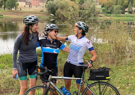 three bikers in front of lake