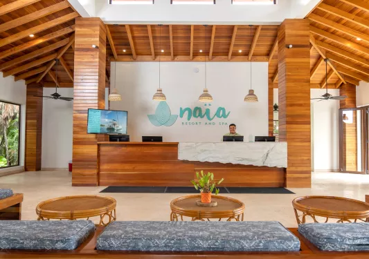 Hotel lobby with circular wooden tables and cushioned benches