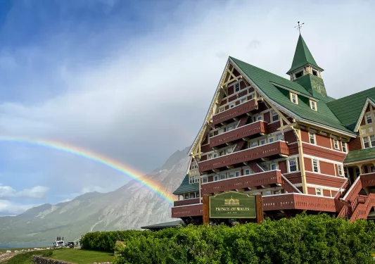 Red building with a green roof, with fog and mountains in the background